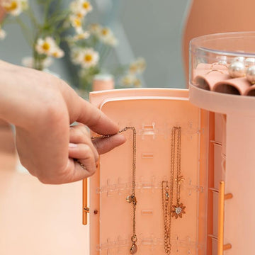 A girl hanging her necklace in our Multi-Layered Jewelry Organizer