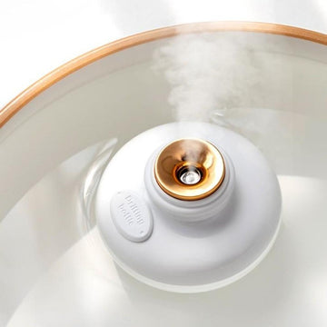 Minimalist stylish humidifier in white floating in glass of water