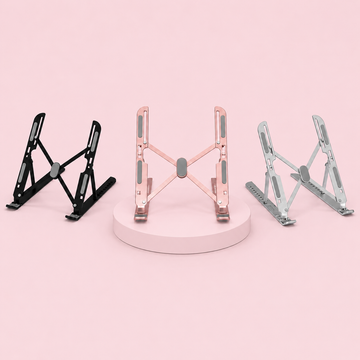 Three laptop stands in black, rose gold, and silver on a pink background