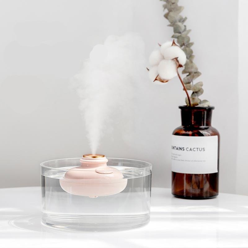 Minimalist stylish humidifier in pink floating in glass of water