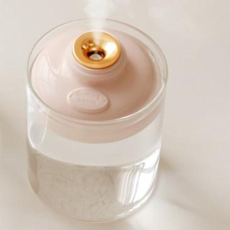 Minimalist stylish humidifier in pink floating in glass of water