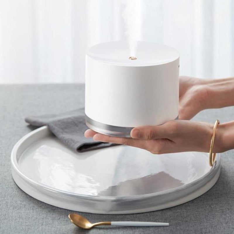 White minimalist humidifier lamp in woman's hands