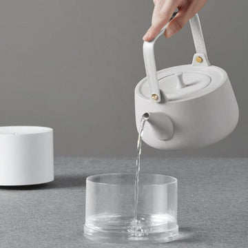 Kettle pouring water in glass for humidifier