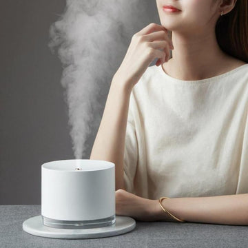 White minimalist humidifier lamp with woman in background