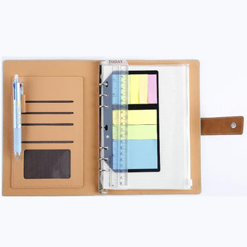 A notebook with pockets ruler, frixion pens, sticky notes, and aa clear pouch