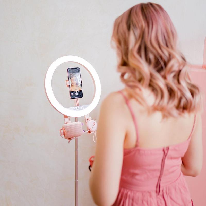 A woman using the pink multitasking foldable self-powered ring light kit