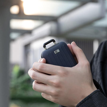 Cute power bank for travel with hand warmer shaped like a suitcase in black in person's hands