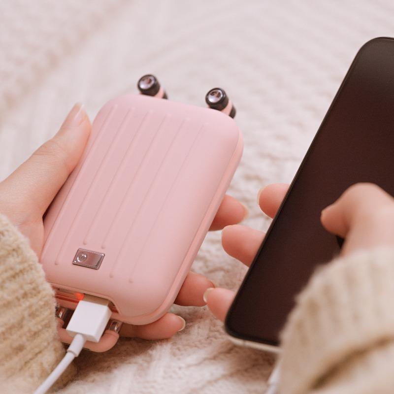 Cute traveler power bank with hand warmer .shaped like a suitcase in pink in woman's hands